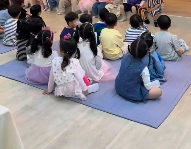 강당에 둘러앉아 발표를 듣는 아이들